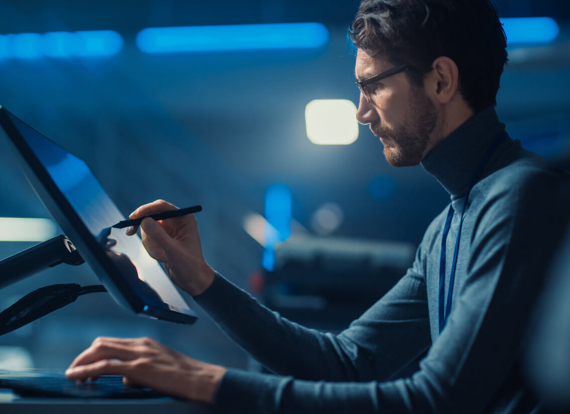 Audiovisual technician using a stylus working on a desktop touchscreen computer