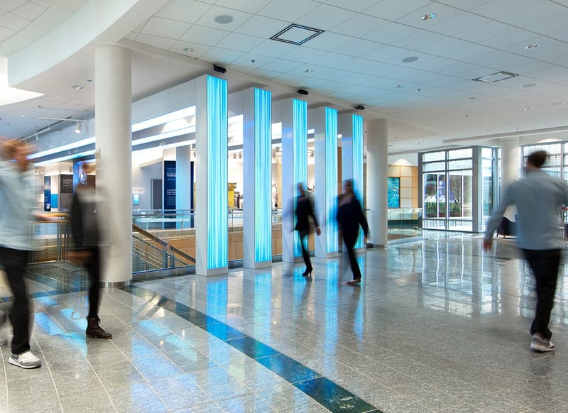 A group of employees walking past LED totems