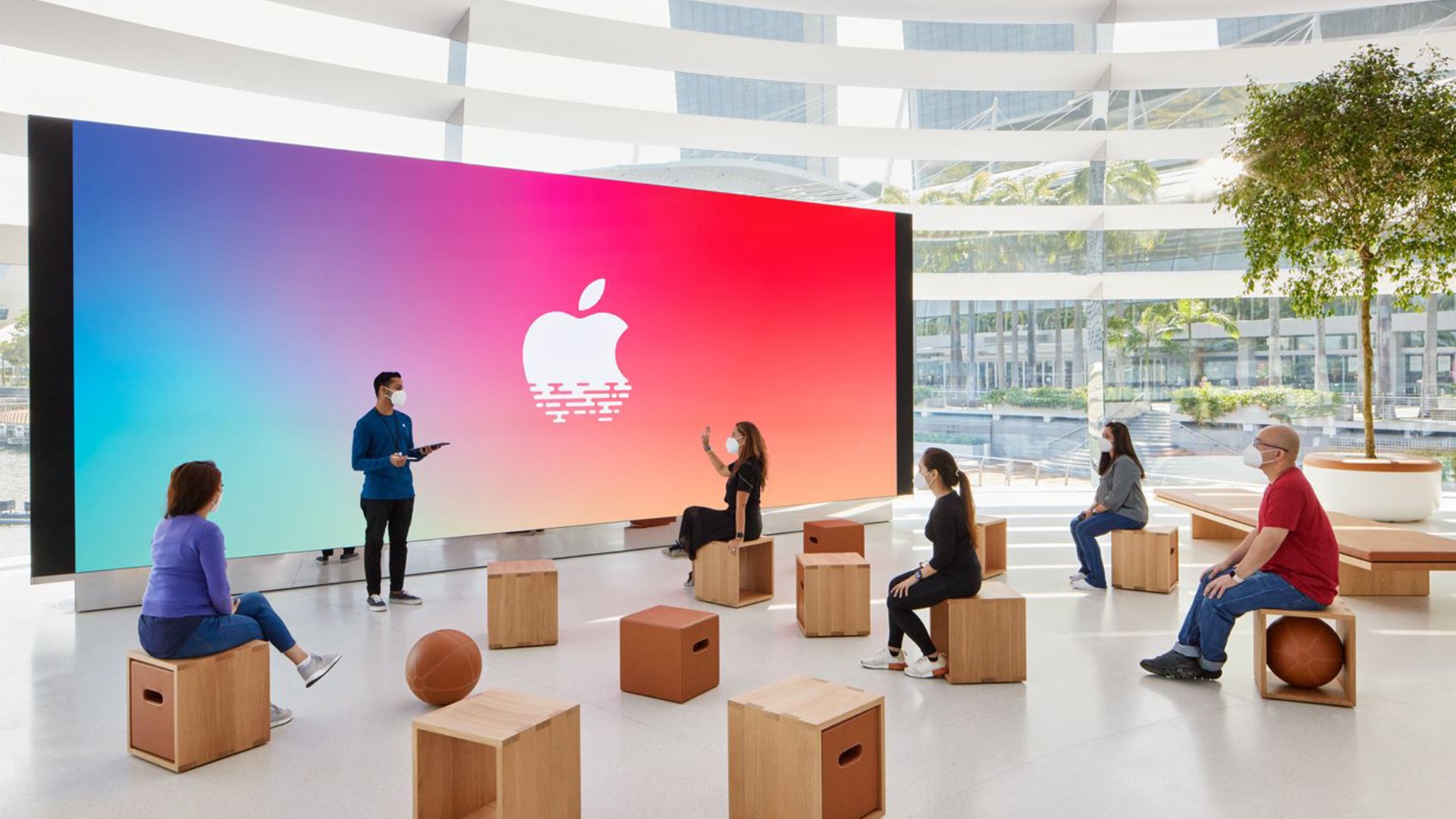 A group of people attend an interactive technology session in a sleek, modern retail space.