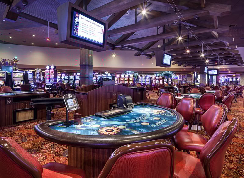 A richly decorated interior of an Indian gaming casino featuring vibrant lighting, traditional design elements, and rows of slot machines and gaming tables that create an exciting and culturally immersive atmosphere.