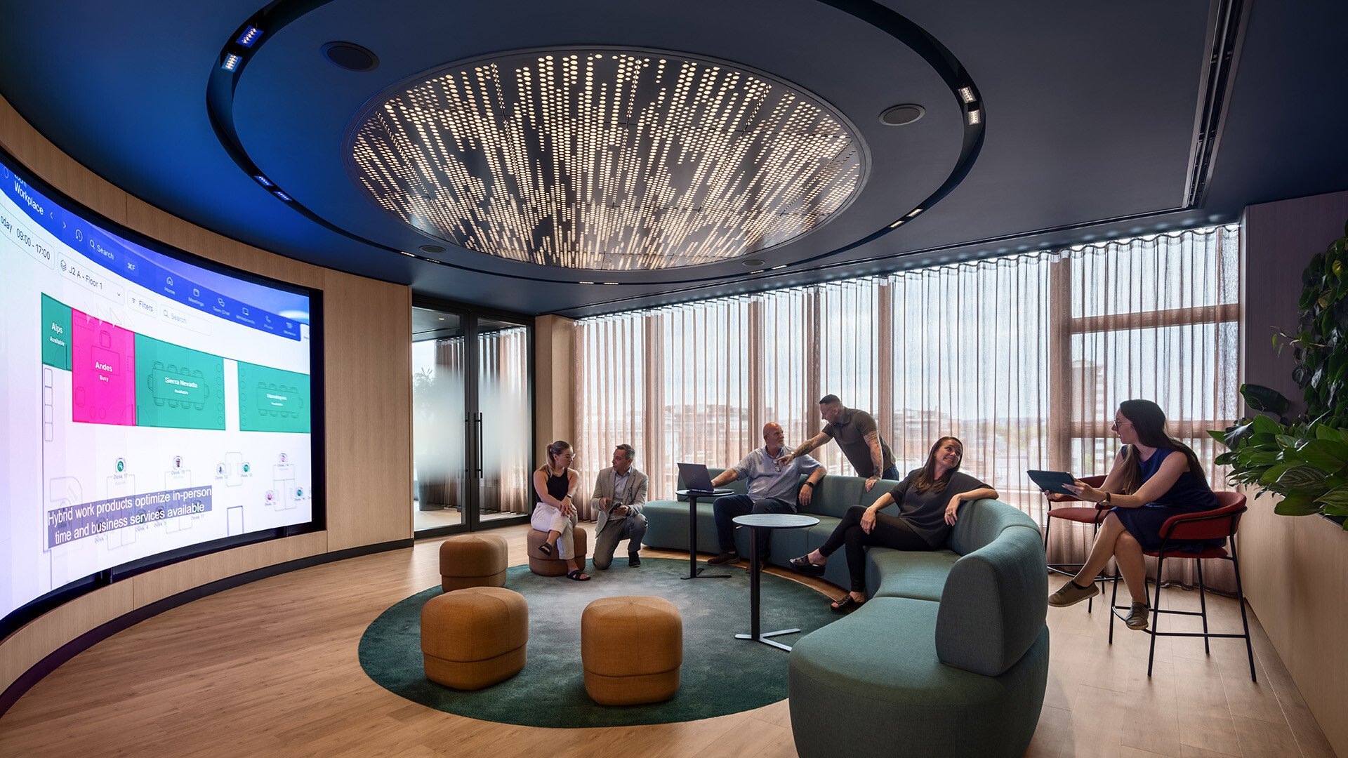 A group of people engaged in conversation in a relaxed meeting room at Zoom, featuring comfortable seating, modern décor, and a collaborative atmosphere.