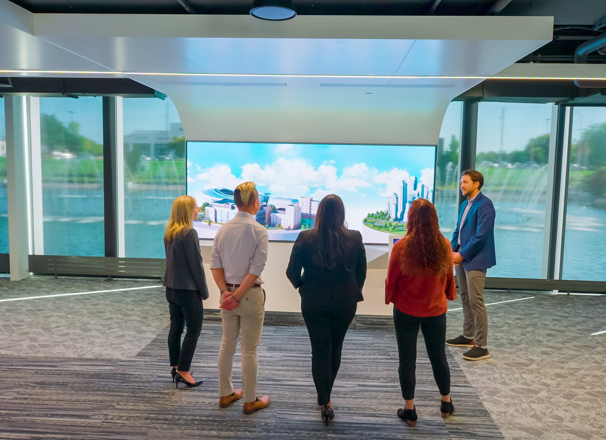 Four customers standing infront of a high definition video wall during a tour of the Johnson Controls innovation center.-1